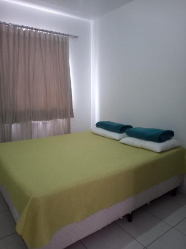 a bed with two pillows on it in a room at Apto 304 sc in Palhoça