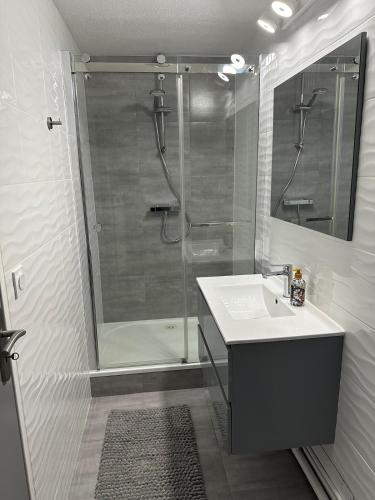 une salle de bain blanche avec une douche et un lavabo dans l'établissement Le Vieux Thannois, à Vieux-Thann