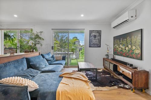 a living room with a blue couch and a fireplace at Spacious 3bdroom entertaining unit close to city, cafes and shops in Brisbane