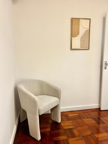 a chair in a room with a picture on a wall at Cantinho do Castelo in Bragança