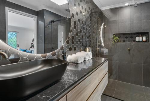a bathroom with a black tub and a sink at Spacious 3bdroom entertaining unit close to city, cafes and shops in Brisbane