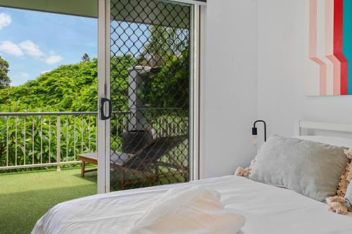 a bedroom with a bed and a screened in porch at Spacious 3bdroom entertaining unit close to city, cafes and shops in Brisbane