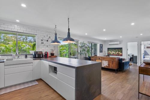 a kitchen with a counter top and a living room at Spacious 3bdroom entertaining unit close to city, cafes and shops in Brisbane
