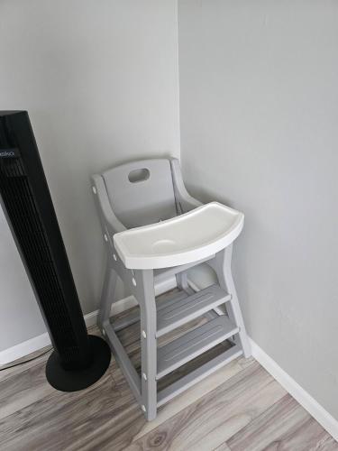 a white stool with a sink next to a wall at Cozy Roomy family sized apartment on major bus route close to all in Orchard Park