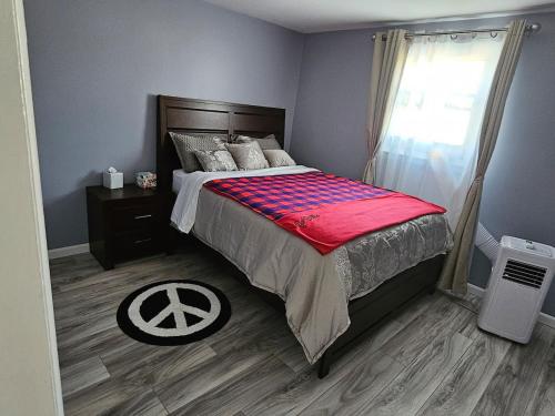 a bedroom with a bed with a red blanket at Cozy Roomy family sized apartment on major bus route close to all in Orchard Park