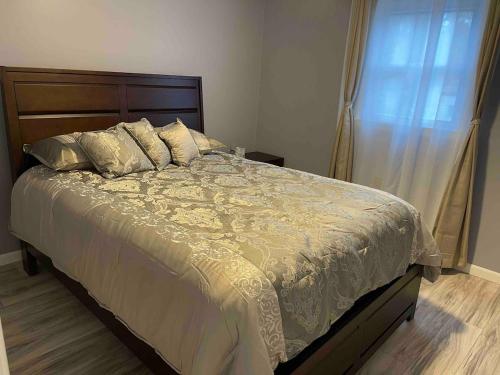 a bedroom with a large bed with pillows and a window at Cozy Roomy family sized apartment on major bus route close to all in Orchard Park