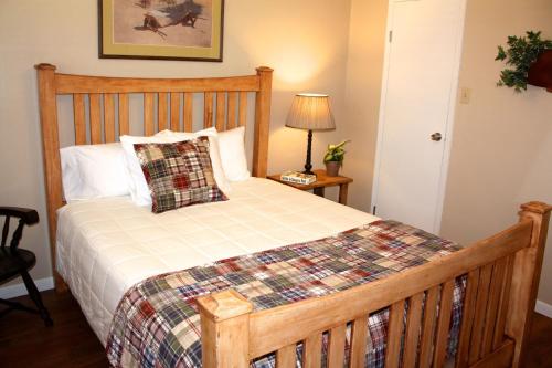 a bedroom with a bed with a wooden headboard at Carlton Club Inn in Kerrville