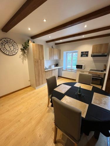 une cuisine et une salle à manger avec une table et des chaises dans l'établissement Joli appartement situé à saales, à Saales