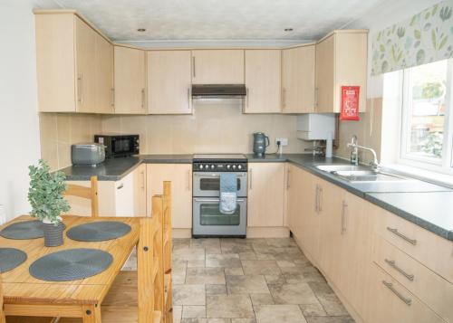 a kitchen with a table and a stove top oven at Parkside House Stevenage in Stevenage