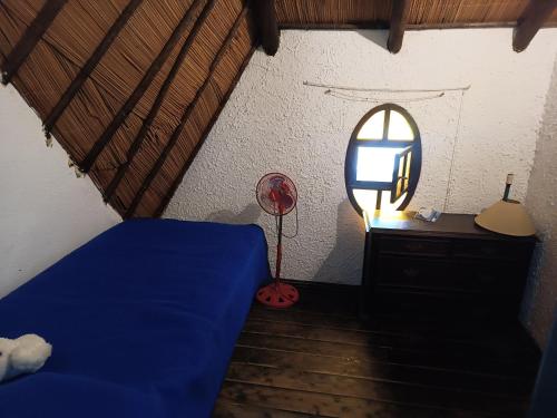 a bedroom with a blue bed and a mirror at Cabaña Floresta in La Floresta