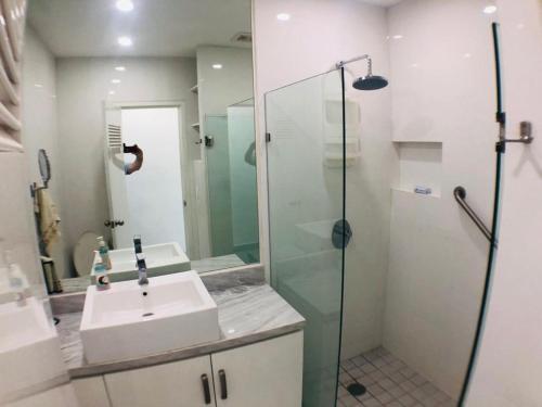 a bathroom with a sink and a glass shower at Aria Ocean Beachfront Condos in Nuevo Vallarta