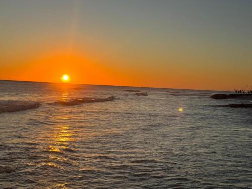 a sunset over the ocean with the sun setting at Golden Acre Beach Villa-2 mins walk - Alleynes Bay in Saint James