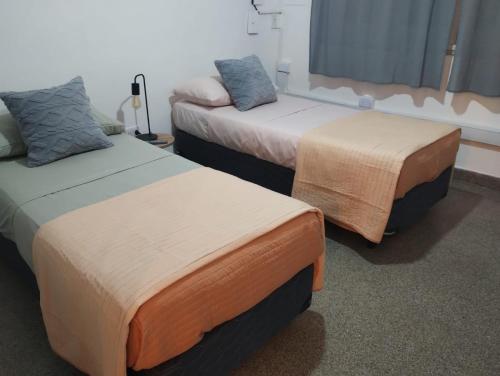 two beds sitting next to each other in a room at Alquileres Allen in Allen