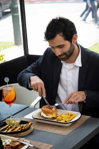 a man sitting at a table eating a plate of food at Casa Andina Premium San Isidro in Lima