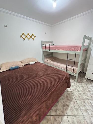 a bedroom with a bed and a bunk bed at Apartamento no centro de Vicosa-ce in Viçosa do Ceará