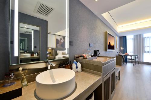 a bathroom with a large sink and a large mirror at Mehood Lestie, Taiyuan South Railway Station in Taiyuan