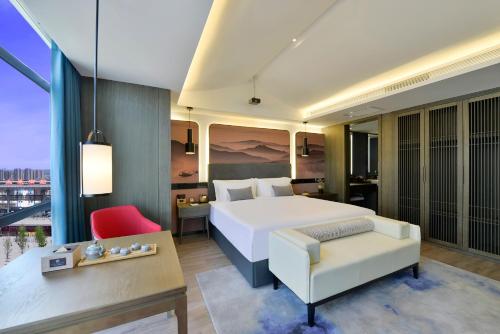 a hotel room with a bed and a table at Mehood Lestie, Taiyuan South Railway Station in Taiyuan