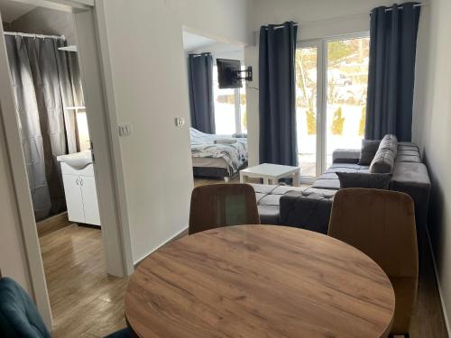 a living room with a table and a couch at HARIZMA LUX Banja Vrujci in Popadić