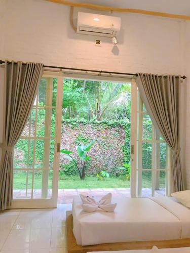 a bedroom with a large sliding glass door at Pasir Putih resort & Cafe in Maluk
