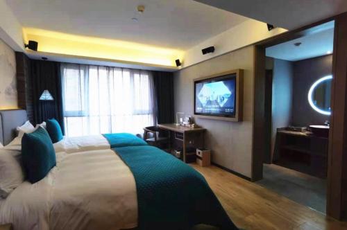 a hotel room with a bed and a television at Mehood Lestie, Beidaming Palace in Xi'an