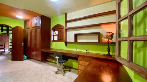 a bathroom with green walls and a desk with a mirror at Casa de Campo - Condomínio Arco Íris in Atibaia