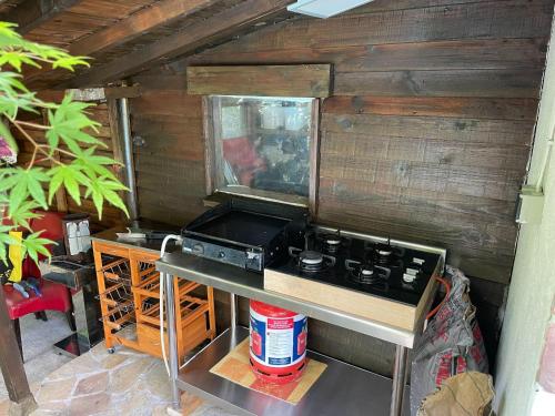 an outdoor kitchen with a stove and a table at Family Holiday Home with Pool in Coray