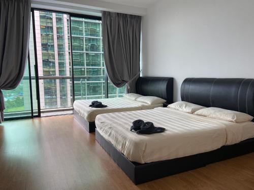 - 2 lits dans une chambre avec de grandes fenêtres dans l'établissement Imperial Suites at Boulevard Mall, à Kuching