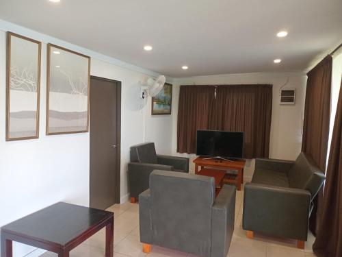 a living room with chairs and a table and a television at Dreamview Villas in Rakiraki