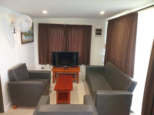 a living room with two couches and a television at Dreamview Villas in Rakiraki