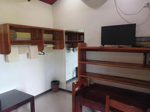a room with a tv and a table and a chair at Dreamview Villas in Rakiraki