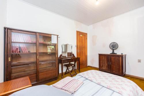 a bedroom with a bed and a dresser and a desk at Memora Guesthouse Curitiba - Quartos em Casa próximo ao Parque Bacacheri in Curitiba