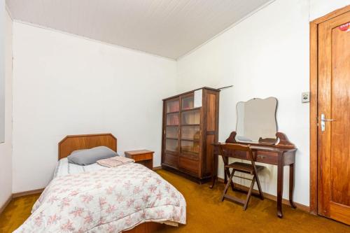 a bedroom with a bed and a dresser and a desk at Memora Guesthouse Curitiba - Quartos em Casa próximo ao Parque Bacacheri in Curitiba