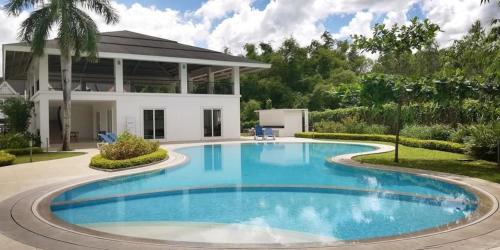 a swimming pool in front of a house at M&B Tropical 3-Bedroom Townhouse at PonteFino Prime in Batangas City
