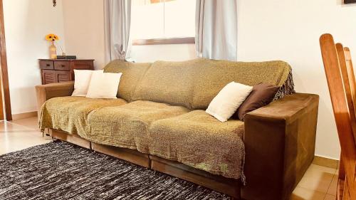 a couch with pillows on it in a living room at Casa temporada Ilhabela in Ilhabela
