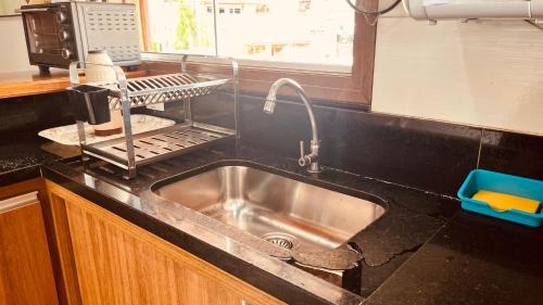 a kitchen counter with a sink and a window at Casa temporada Ilhabela in Ilhabela