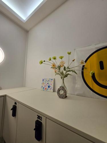 a vase with flowers on a counter in a room at Busan Circle Stay Hotel in Busan