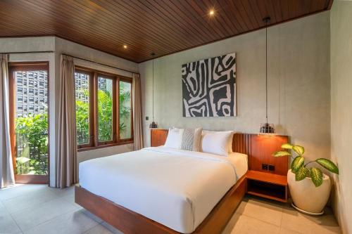 a bedroom with a large bed and a window at Raya Villa by Betterplace in Canggu