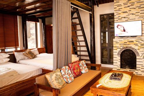a living room with two beds and a fireplace at Chuồn Chuồn Villa Homestay Tam Đảo in Tam Ðảo