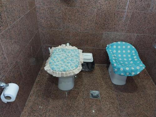 a tiled bathroom with a toilet and a blue seat at Big House in Merlo