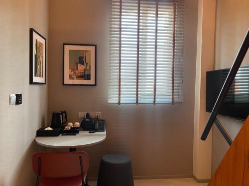 a room with a white table and a window at Wanderlust, The Unlimited Collection managed by The Ascott Limited in Singapore