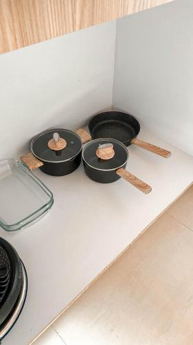 three pans sitting on top of a white counter at Villa Elior Selong Belanak, South Lombok in Selong Belanak