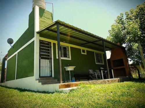 ein grünes und weißes Haus mit einer Veranda in der Unterkunft Casa san Pedro de colalao in San Pedro de Colalao