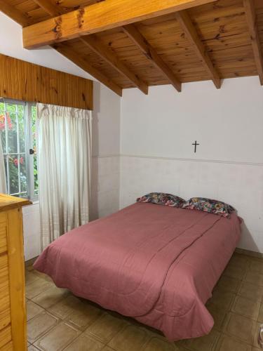 ein Schlafzimmer mit einem Bett mit einer lila Decke in der Unterkunft Casa playa Valeria in Valeria del Mar