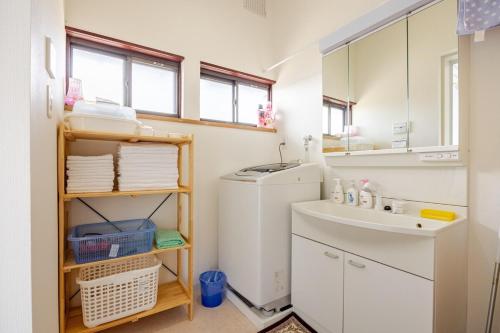 un piccolo bagno con lavandino e frigorifero bianco di BLO富津市大堀-Private Villa in Futtsu a Futtsu
