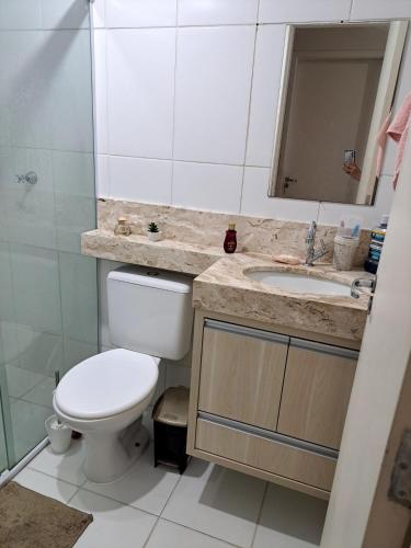 a bathroom with a toilet and a sink at Apto Completo, proximo ao Shopping in Taubaté