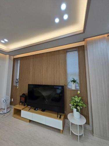 a living room with a large flat screen tv at Daori Pension in Boryeong