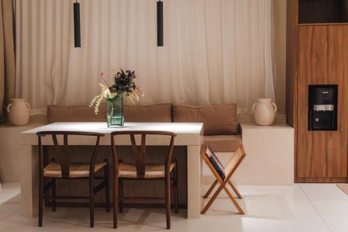 a table and chairs with a vase of flowers on it at Sore Escape Tumbak Bayuh by Betterplace in Tumbak Bayuh