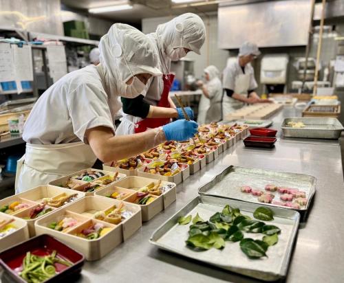 two chefs preparing food in a kitchen at 美咲旅館 in Sakaide
