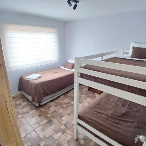 a bedroom with two bunk beds and a window at Aysen Bike Cabañas in Puerto Aisén