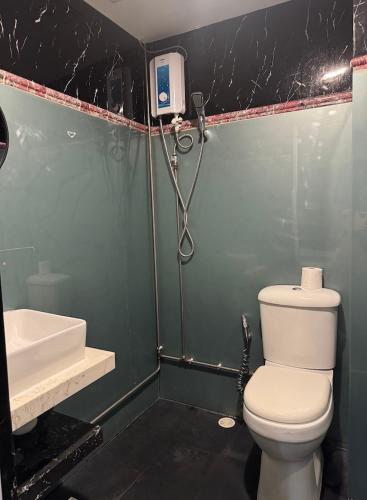 a bathroom with a toilet and a shower and a sink at HOTEL JJH Aliwal in Singapore